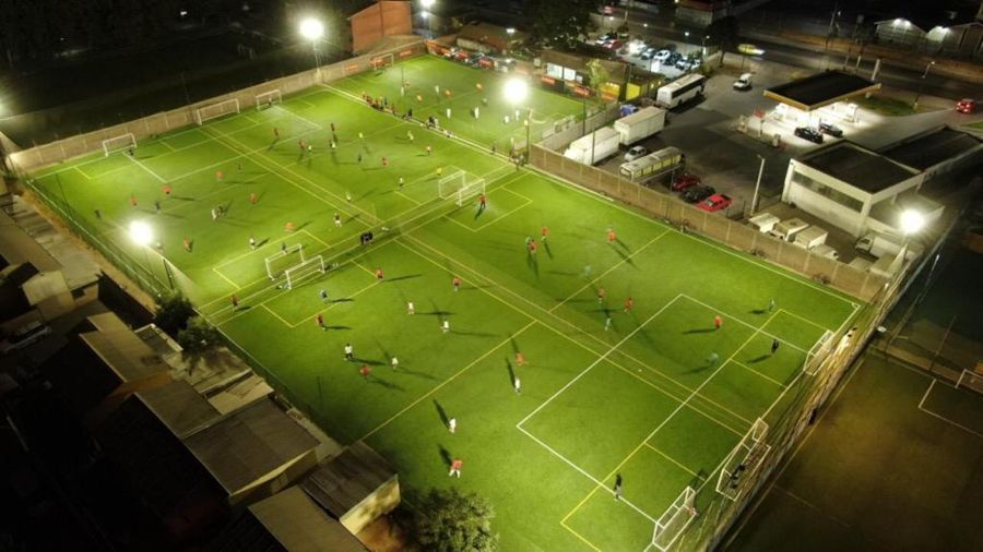 Vista aérea nocturna de las canchas de la sede Puente Alto con partidos en juego